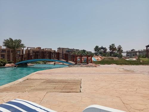 a pool at a resort with a bridge and water at Blue Bay Asia Sokhna Aqua park بلو باي اسيا العين السخنه - عائلات فقط in Ain Sokhna