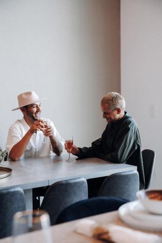 two men sitting at a table drinking wine at Level Los Angeles - Downtown South Olive in Los Angeles