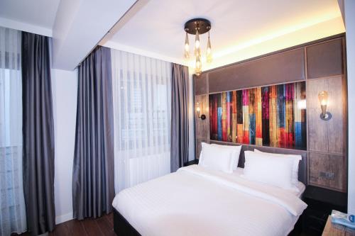um quarto com uma cama branca e um quadro na parede em Home of Galataport em Istambul