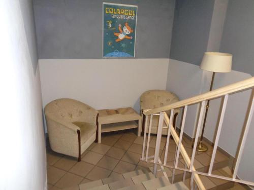 a room with two chairs and a table and a staircase at GO Hostel Rewolucji in Łódź
