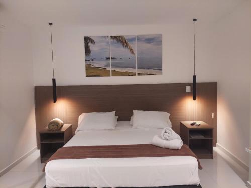 a bedroom with a large white bed with two night stands at Bahia San Andres Hospedaje in San Andrés