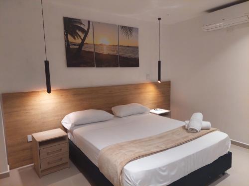 a bedroom with a large bed with a wooden headboard at Bahia San Andres Hospedaje in San Andrés