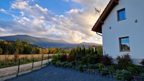 a house with a view of the mountains at Widokowo - Domki z widokiem na Śnieżkę z Jacuzzi i Sauną in Karpacz