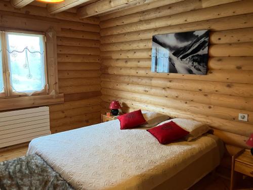 a bedroom with wooden walls and a bed with red pillows at Saint Bernard in Font-Romeu-Odeillo-Via