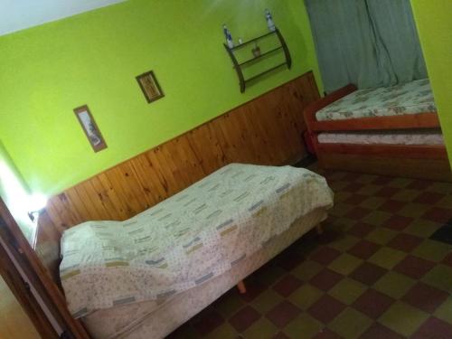 1 dormitorio con 2 camas y pared verde en Depto San Clemente del tuyu centro en San Clemente del Tuyú