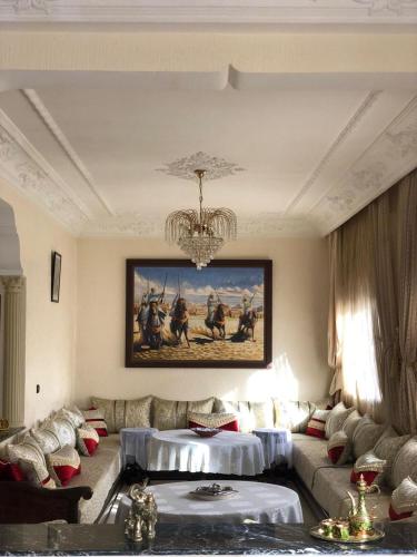 a living room with a couch and a painting on the wall at GAMRA Villa in Agadir