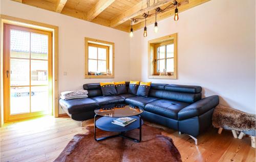 a living room with a black leather couch at Schoenes Holzhaus In Flattnitz in Flattnitz