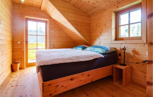 a bed in a log cabin with two windows at 3 Bedroom Nice Home In Flattnitz in Flattnitz