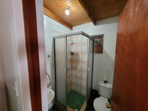 uma casa de banho com um WC e uma cabina de duche em vidro. em Lalck Cketi Hospedaje y Turismo em San Pedro de Atacama