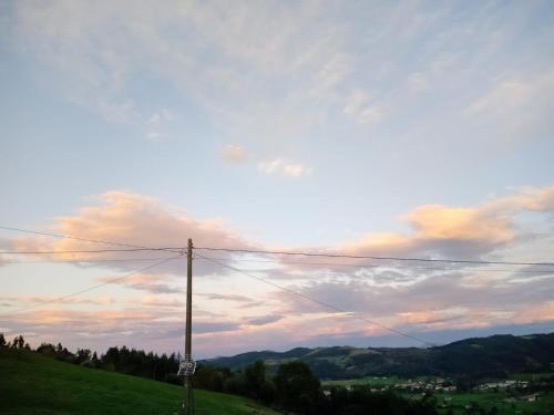 a telephone pole on a hill with a cloudy sky at Casa del cristo in Solórzano