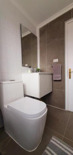 a bathroom with a white toilet and a sink at Casa Descanso Serena in La Serena