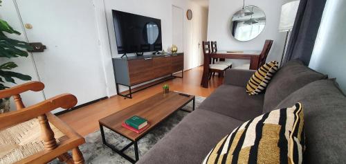 ein Wohnzimmer mit einem Sofa und einem TV in der Unterkunft Casa Descanso Serena in La Serena