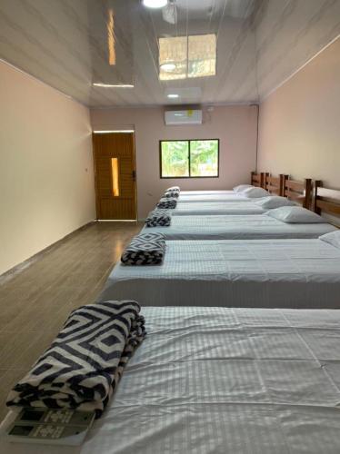 a row of beds in a large room at Buritaca House in Buritaca