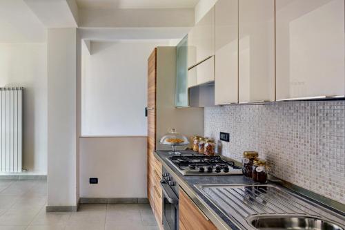 a kitchen with white cabinets and a stove top oven at Agriturismo Statale 17 in Poggio Picenze