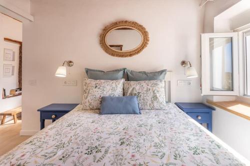 a bedroom with a bed with blue tables and a mirror at Vivienda Vacacional Rosa Blanca in Arure