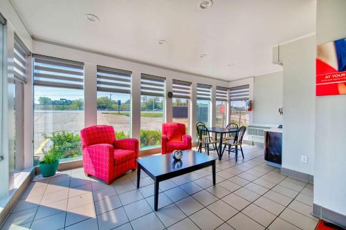 a living room with red chairs and a table at Motel 6-Fort Worth, TX - White Settlement in Fort Worth