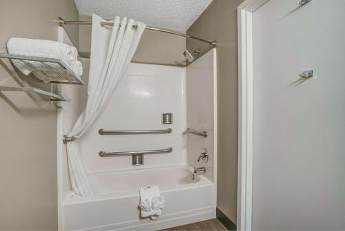 a bathroom with a bath tub with a shower curtain at Motel 6-Fort Worth, TX - White Settlement in Fort Worth
