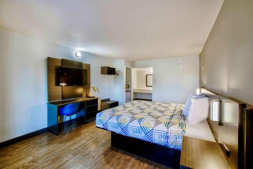 a bedroom with a bed and a desk and a television at Motel 6-Fort Worth, TX - White Settlement in Fort Worth