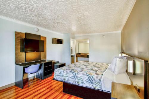 a hotel room with a bed and a desk at Motel 6-Fort Worth, TX - White Settlement in Fort Worth