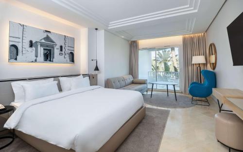 a bedroom with a large white bed and a desk at Radisson Blu Palace Resort & Thalasso, Djerba in Houmt Souk