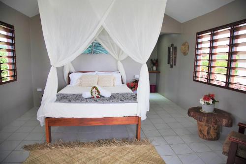 a bedroom with a bed with a canopy at Le Life Resort in Epule