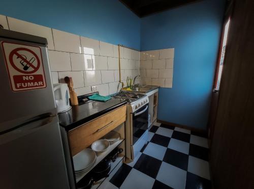 una pequeña cocina con fogones y nevera. en Kapai Departamentos de Turismo, en Valdivia