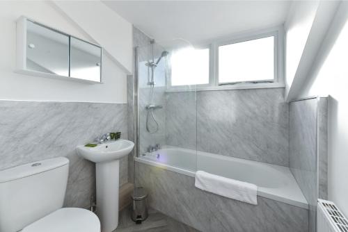 a bathroom with a shower toilet and a sink at Newark Central Cottage in Newark-on-Trent