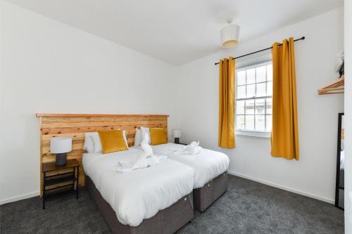 2 camas individuales en una habitación con ventana en Newark Central Cottage, en Newark-on-Trent