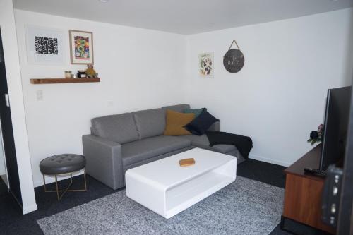 a living room with a couch and a coffee table at Bach On Daniel in Martinborough 