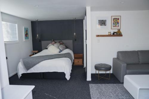 ein Schlafzimmer mit einem Bett und einem Sofa in der Unterkunft Bach On Daniel in Martinborough 