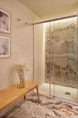 a glass shower with a vase on a wooden table at MIRACONCHA TERRACE by SWEET HOME SAN SEBASTIAN in San Sebastián
