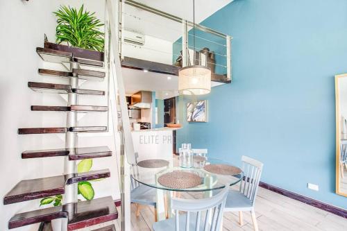 Un comedor con una mesa de cristal y sillas. en CR MARIPOSA RENTALS Lakeview PENTHOUSE with office space, pool, gym, tennis, en Santa Ana