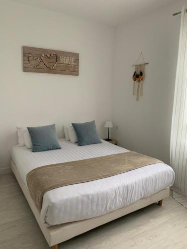 a bedroom with a large bed with two pillows at LOGIS HOTELS - Hôtel et Restaurant L'Océana in Lanton