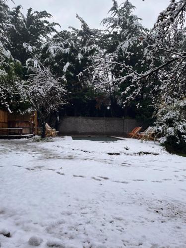 a yard covered in snow with a fence and trees at El Encanto del Manzano & Espacio Vittalia Spa in San José de Maipo
