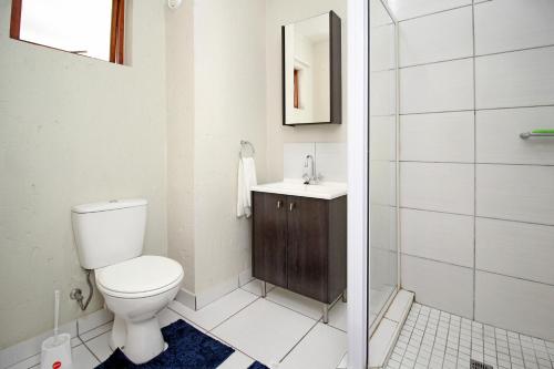 uma casa de banho com um WC, um lavatório e um chuveiro em GREENWICH 2 bedroom 2 bath serv apart with 24hrs electricity em Sandton