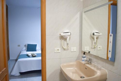 a bathroom with a sink and a mirror and a bed at apartamento sabare rambla in Frontera