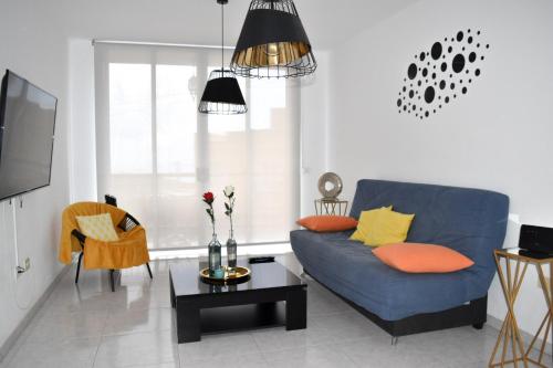a living room with a blue couch and a table at apartamento sabare rambla in Frontera
