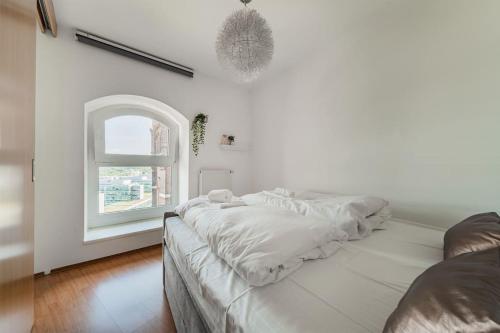 biały pokój z łóżkiem i oknem w obiekcie Spektakuläres Apartment ✩ 7. Stock ✩ kostenlose Parkgarage w Wiedniu