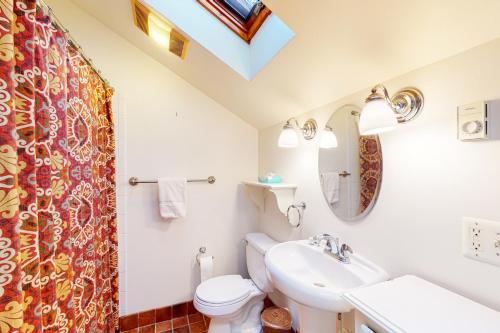 a bathroom with a white toilet and a sink at Little Brown House in Glen Arbor