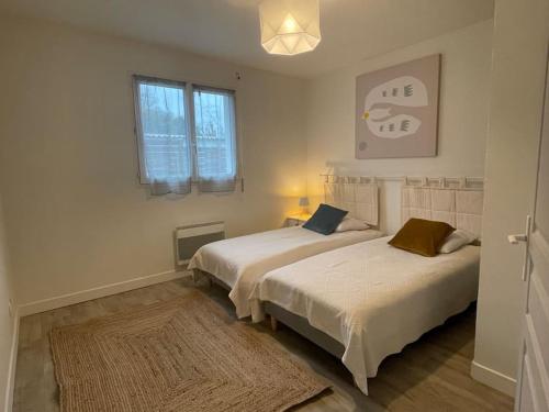 a bedroom with two beds and a rug at La Casa Montussan in Montussan