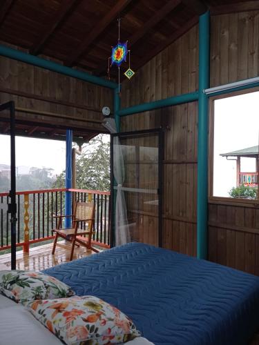 a bedroom with a bed and a balcony with windows at Jaibaná Spa in Támesis