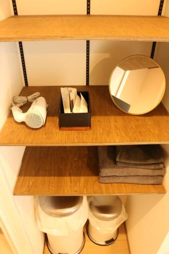 a bathroom shelf with a mirror and toiletries at GLANSTELLA CABIN Fujiyamanakako in Yamanakako