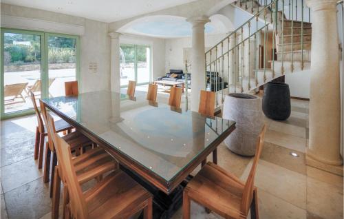 une salle à manger avec une table en verre et des chaises en bois dans l'établissement Gorgeous Home In Saint Raphael, à Valescure