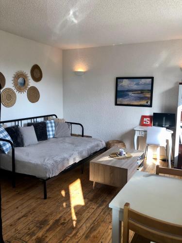 un salon avec un lit et une table dans l'établissement Sables d Or Studio 22 à 300 mètre de la plage, à Fréhel