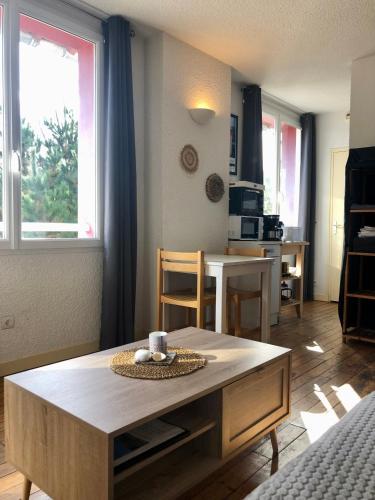 un salon avec une table et une cuisine dans l'établissement Sables d Or Studio 22 à 300 mètre de la plage, à Fréhel