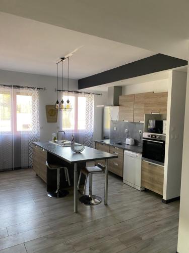 a kitchen with a table and a sink in it at Gîte de l’Europe in Biville-sur-Mer