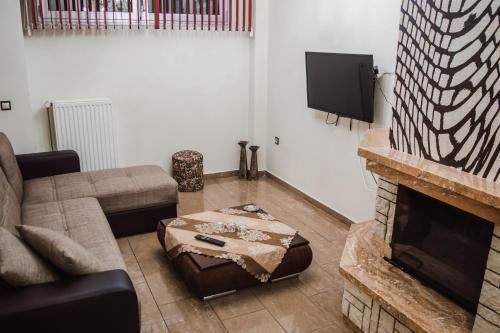 a living room with a couch and a fireplace at g.home in Tríkala