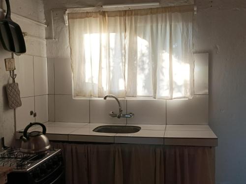 a kitchen counter with a sink and a window at Casa Vapahí in Barra de Valizas