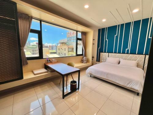 um quarto com uma cama, uma mesa e uma janela em 14 Art Villa em Tainan