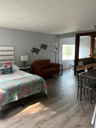 una camera con letto, sedia e tavolo di The Guesthouse Ocean View Cottages a Cannon Beach